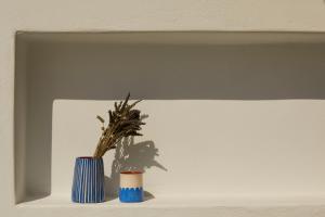 twee blauwe vazen op een plank met een plant bij Isychos House in Mikri Vigla