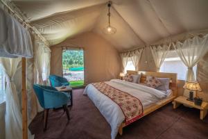 1 dormitorio con 1 cama en una tienda de campaña en Eskape Camps, en Saturang