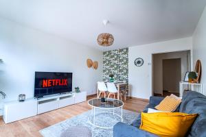 Appart moderne tout confort La Clef d'Élancourt في إيلانكورت: غرفة معيشة مع أريكة زرقاء وتلفزيون