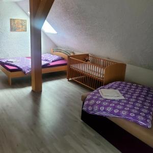 a bedroom with two twin beds and a crib at FeWo im Gasthof Forsthaus in Marktredwitz