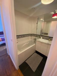 La salle de bains est pourvue d'une baignoire et d'un lavabo. dans l'établissement Plein cœur quartier Montorgueil, à Paris