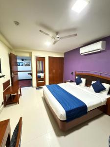 a bedroom with a large bed and a purple wall at Hotel Divine Admire Opp Gurudwara Sahib in Taimoor Nagar-Friends Colony in New Delhi
