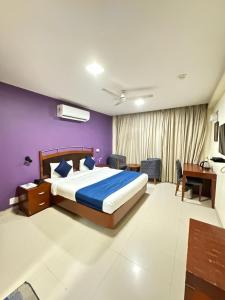een slaapkamer met een bed en een paarse muur bij Hotel Divine Admire Opp Gurudwara Sahib in Taimoor Nagar-Friends Colony in New Delhi