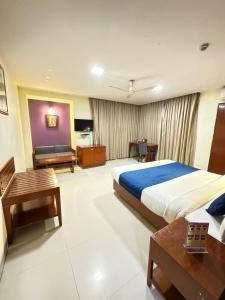 um grande quarto de hotel com uma cama e um sofá em Hotel Divine Admire Opp Gurudwara Sahib in Taimoor Nagar-Friends Colony em Nova Deli