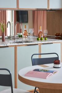 cocina con mesa y fregadero con copas de vino en Turing Locke Cambridge, en Cambridge