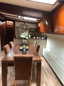 een eetkamer met een houten tafel en stoelen bij Klipper Johanna in Monnickendam