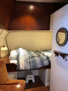 a small bedroom with a bed and a mirror at Klipper Johanna in Monnickendam