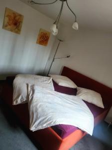 a bedroom with a bed with white sheets and pillows at FeWo im Gasthof Forsthaus in Marktredwitz