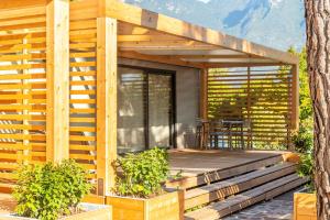 a wooden deck on a house with a table at Campeggio Garda in Limone sul Garda