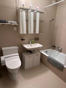 a bathroom with a toilet and a sink and a tub at Mon Bijoux in Ascona