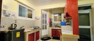 une petite cuisine avec des placards rouges et un poteau rouge dans l'établissement Blue Haven Unit 3, à Baguio