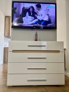 a tv sitting on top of a white dresser at Belveder Center Home in Ivano-Frankivsk