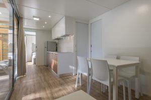 una cucina e una sala da pranzo con tavolo e sedie di Camping Park Garda a Limone sul Garda