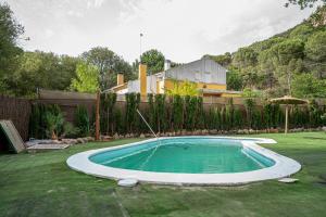 a swimming pool with a hose in a yard at Casa los Jardines del Lago in Córdoba
