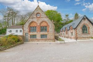 un gran edificio de ladrillo con un reloj. en Chequers Lodge- Dalton-in- Furness- Self check in en Dalton in Furness