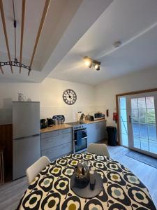 uma cozinha e uma sala de jantar com uma mesa num quarto em Coastal Cottage - Cellardyke Anstruther em Anstruther