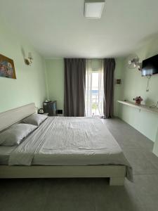 Un dormitorio con una cama grande y una ventana en Ginger Sihanoukville, en Sihanoukville