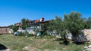a house with a fence in front of it at Holiday house Valencan 2 in Mednjan +6 photos