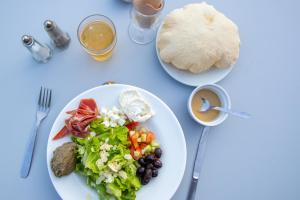 uma mesa com um prato de salada e um prato de pão em LA FONTAINE D'ANNIBAL em Buis-les-Baronnies