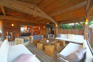 a porch with white furniture and a wooden ceiling at Villa Lodge Natureo in Seignosse