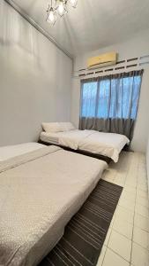 2 camas en una habitación con ventana en 311 Nana’s Homes BBQ, Games, Netflix 11pax en Ampang