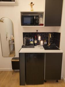 a kitchen with a sink and a microwave at Nuit d'évasion love room avec baignoire balnéothérapie in Toulon