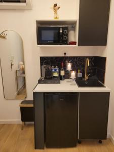 une cuisine avec un évier et un micro-ondes dans l'établissement Nuit d'évasion love room avec baignoire balnéothérapie, à Toulon 12 autres photos