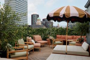 eine Dachterrasse mit Stühlen und einem Sonnenschirm in der Unterkunft Grand Joanne in Kopenhagen