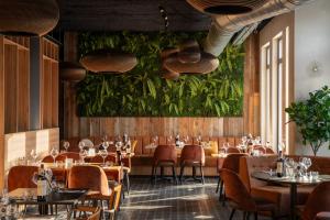 a restaurant with tables and chairs and a green wall at Dormio Resort Maastricht in Maastricht