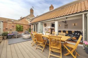 a patio with a wooden table and chairs at Tern Cottage in Burnham Market