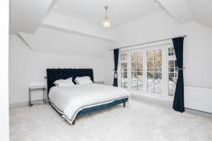 a white bedroom with a bed and a window at Ferry house in Marlow
