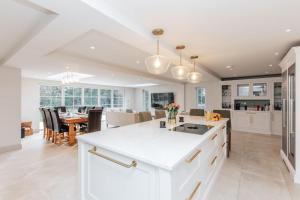 a kitchen and dining room with white cabinets and a table at Ferry house in Marlow