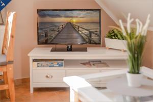 a tv sitting on top of a white dresser at Ferienwohnung Thurbruch in Zirchow