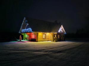 Una casa iluminada con luces de Navidad por la noche en Meijas Nams, en Kalupe