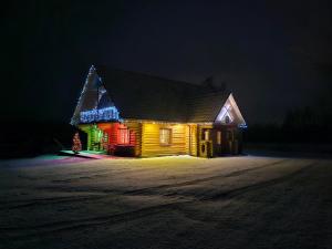 a house lit up with christmas lights at night at Meijas Nams in Kalupe