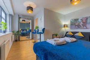 1 dormitorio con cama azul y manta azul en City Skyline View Studio Apartment - Birmingham Central en Birmingham