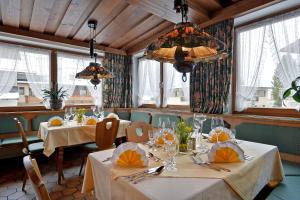 a dining room with tables and chairs and windows at Hotel Schwarzer Adler in Hippach