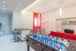 un tavolo da ping pong in una stanza con un divano rosso di Navile, Bologna By Short Holidays a Bologna