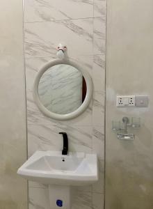 een badkamer met een witte wastafel en een spiegel bij White Star Ocean View Hotel in Paje