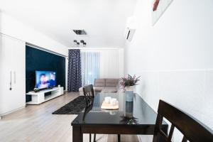 a living room with a table and a couch at Opal Luxury Aviatiei in Bucharest