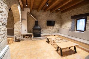 a large room with a fireplace and tables and a couch at Mas el Coll in El Gurb