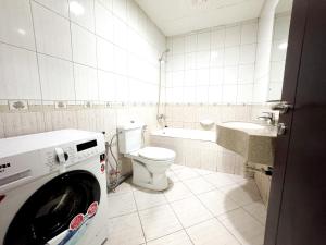 a bathroom with a toilet and a washing machine at Nahda Star Residence - Home Stay in Dubai