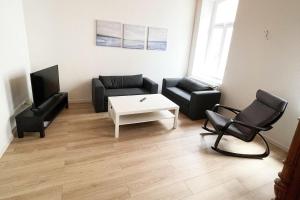 ein Wohnzimmer mit einem Sofa und einem Tisch in der Unterkunft Work & Stay Apartment in Stolberg bei Aachen in Stolberg