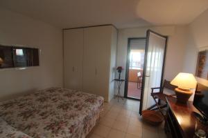a bedroom with a bed and a dresser and a table at Verdemare Pineta in Lignano Sabbiadoro