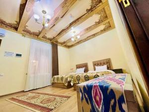 um quarto com 2 camas e um tecto em caixote em Mevlana Hotel em Samarkand
