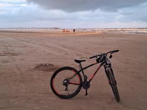 a bike parked on the beach near the ocean at kitnets Luz Beira mar in Tramandaí