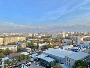 een luchtzicht op een stad met bergen op de achtergrond bij Просторная двухкомнатная квартира в ЖК Ala-Park Егизбаева 3 in Alma-Ata