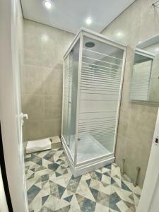 een douche met een glazen deur in de badkamer bij Просторная двухкомнатная квартира в ЖК Ala-Park Егизбаева 3 in Alma-Ata