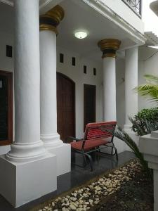un banco rojo sentado en el exterior de un edificio en Homestay Propline en Bogor