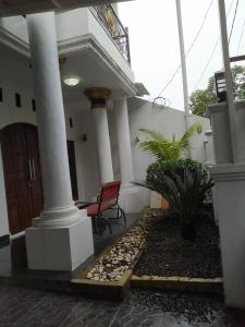 a front porch of a house with a red chair at Homestay Propline in Bogor